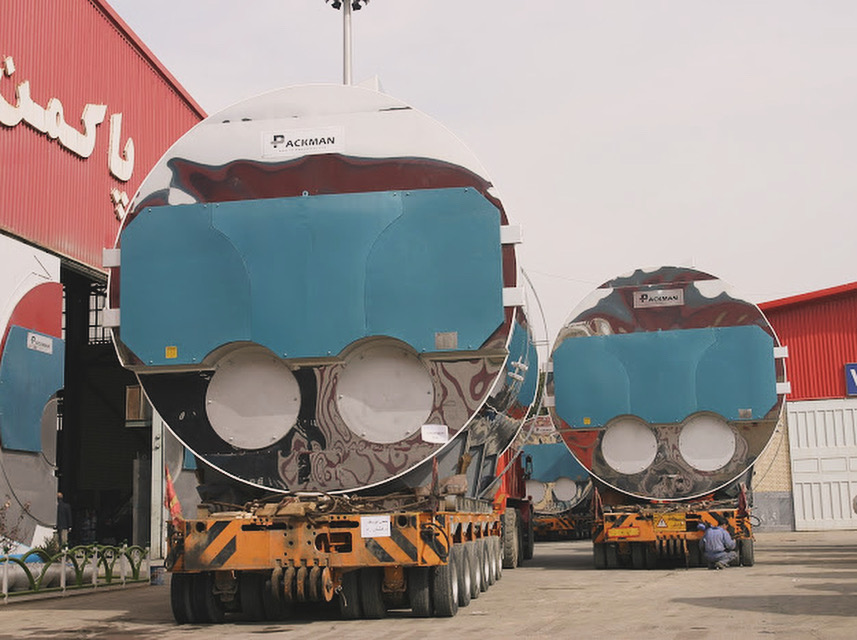 Packman boilers on heavy-haul trailers outside the factory, with the company name visible